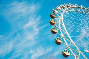 Ferris wheel against a clear blue sky with wispy clouds.