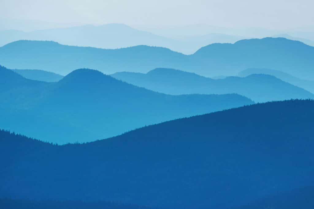 Layers of blue mountains creating a serene, misty landscape.