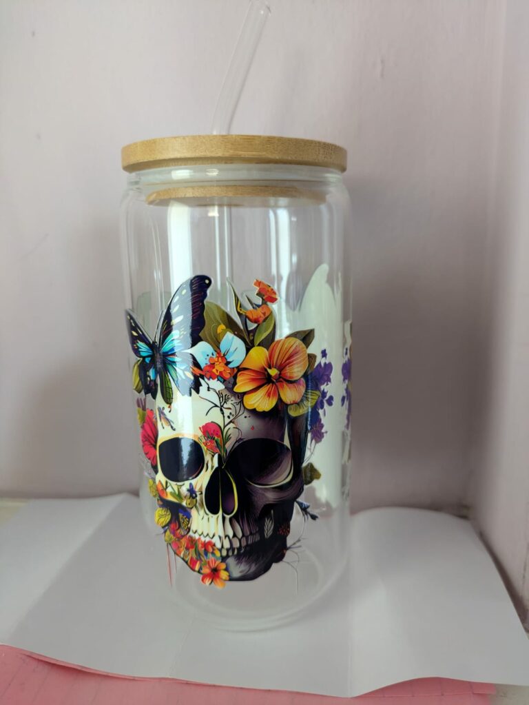Glass jar with bamboo lid, decorated with colorful flowers, a butterfly, and a skull design.